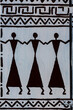 African drawing on a white wall with ornaments and figures of people, closeup
