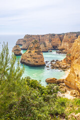 Wall Mural - Cliffs and ocean, vertical photography of Praia da Marinha, Algarve, Portugal