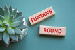 Funding Round symbol. Concept words Funding Round on wooden blocks. Beautiful grey green background with succulent plant. Business and Funding Round concept. Copy space.