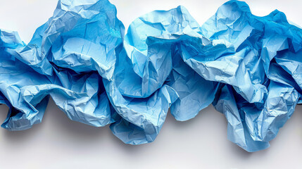   A tight shot of numerous blue tissue papers scattered on a pristine white table, against a backdrop of a pristine white wall