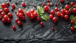   A collection of red berries atop a black slate, adorned with accompanying leaves