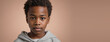 An African American Kin Boy, Isolated On A Peach Background With Copy Space