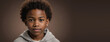 An African American Juvenile Boy, Isolated On A Brown Background With Copy Space