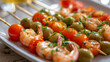 Shrimp skewers on sticks cherry tomatoes green olives on a plate