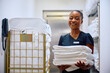 Happy black chambermaid working in  hotel and looking at camera.
