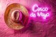 vibrant pink sombrero with cinco de mayo neon sign on textured background