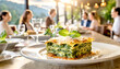 Lasagne mit Spinat im Hintergrund ein Restaurant mit Gästen 