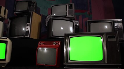 Wall Mural - old analogue televisions with chroma key green screen. front angle view. dolly shot. zoom in.