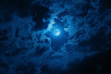 Amazing scenery of blue glowing moon in dark blue sky with clouds at night