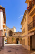 Street in Alcudia old town leading to the stone gate Porta del moll in Mallorca, Spain, Balearic Islands