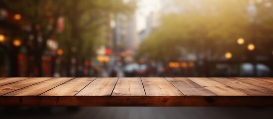 Poster - A wooden table top is shown with a blurred backdrop of city lights shining in the distance