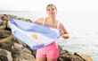 Portrait of happy woman of Argentina match waving a national flag on the seashore on a sunny day
