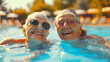 Dos señoras felices riendo y disfrutando de la piscina en un viaje de turismo en verano dentro del agua con gafas y mucho sol y colores.
