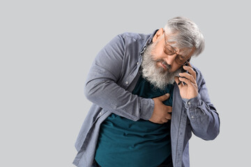 Poster - Middle-aged man with heart attack calling ambulance on grey background