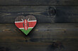 wooden heart with national flag of kenya on the wooden background.