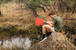 Boy catching tadpoles. Outdoor nature activity.