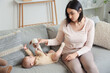 Young woman with toy and her baby suffering from postnatal depression on sofa at home