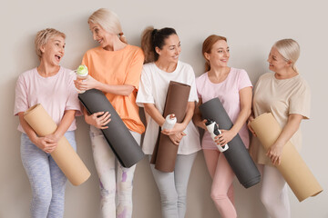 Sticker - Group of mature women with yoga mats and water bottles on light background