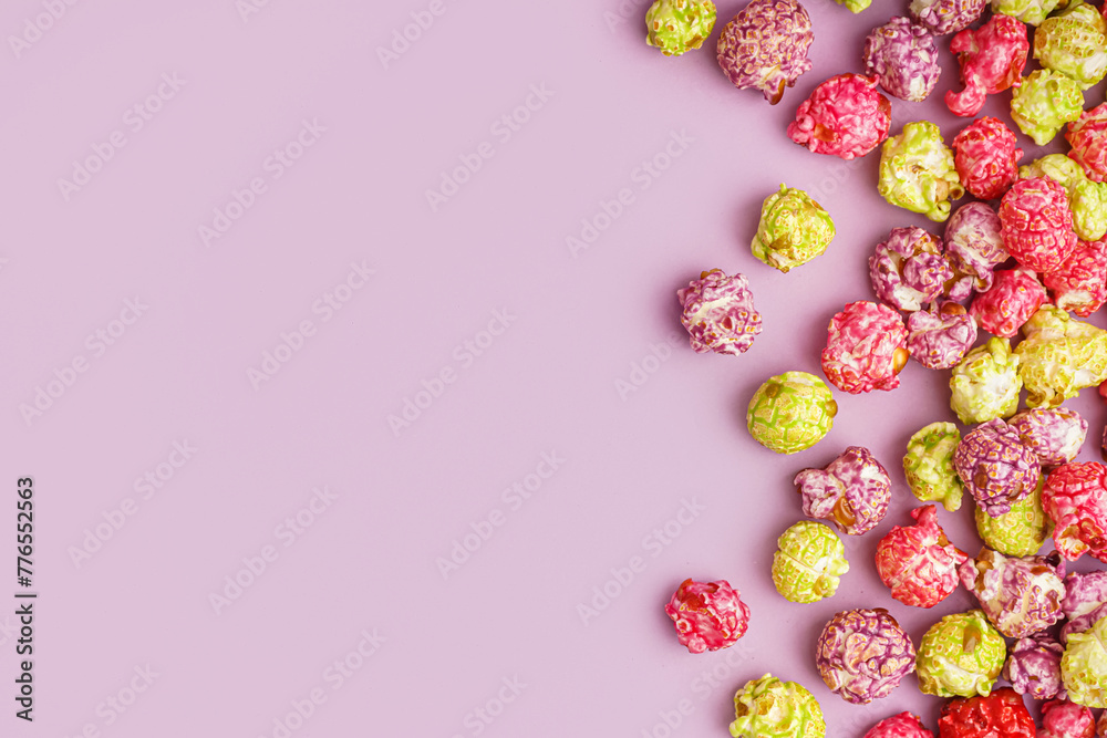 Sweet colorful popcorn on lilac background