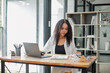 © Satori Studio - Real estate agent attentively examines property listings on her laptop in a stylishly furnished office, symbolizing professionalism and dedication.