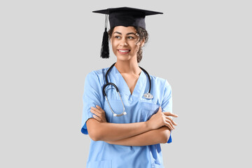 Wall Mural - African-American female medical graduate student on white background