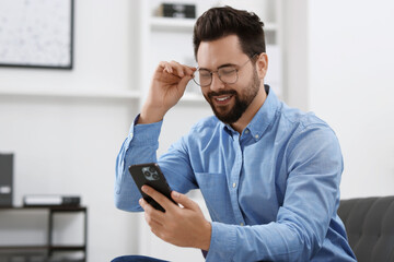 Sticker - Handsome young man using smartphone in office