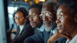 Group of black business people together in a meeting watching screens