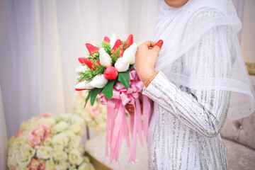 Wall Mural - Beautiful bouquet of different colors in the hands of the bride in a white dress. Bride holding her bridal bouquet.