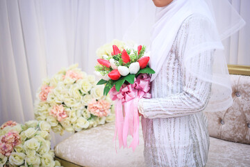 Wall Mural - Beautiful bouquet of different colors in the hands of the bride in a white dress. Bride holding her bridal bouquet.