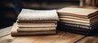 A close up view of a neat stack of folded towels placed on a rustic wooden table, creating a cozy and inviting atmosphere