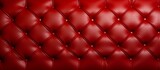 Fototapeta Sypialnia - Lavish red leather couch featuring intricate diamond design, adding a touch of sophistication to any room