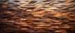 Numerous assorted shapes are intricately carved into a close-up view of a wooden wall, creating a visually interesting pattern