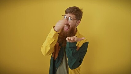 Wall Mural - Sneaky, smiling redhead, young man with glasses, business shirt, strikes 'money sign' pose asks for salary hike, gripping success against yellow backdrop - classic worker's standoff.