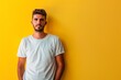© MediaRaw - A man in a white shirt stands in front of a yellow wall