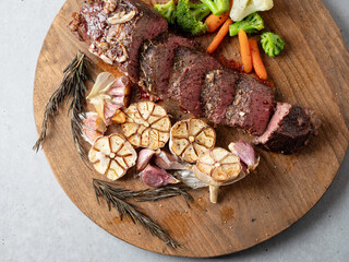 Sticker - Cut steak and roasted garlic on a cutting board