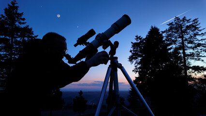 Wall Mural - amateur astronomer looking at the evening skies, observing planets, stars, moon and other celestial 