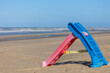 A plastic playground slide on the beach of the North Sea in front of a rough sea