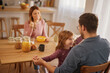 © Stockphotodirectors - Happy family having breakfast at table in kitchen