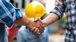 Man holding hard hat are shake hand on site construction concept teamwork business worker