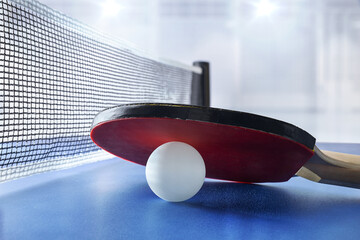 Wall Mural - Ping-pong paddle resting on ball on table in sports hall