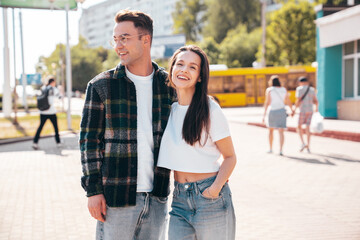 Wall Mural - Smiling beautiful woman and her handsome boyfriend. Woman in casual summer clothes. Happy cheerful family. Female having fun. Sexy couple posing in the street at sunny day