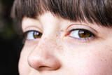 Fototapeta  - Close-up of child's freckled face with expressive eyes