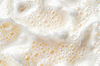 Close up of soapy foam texture as a background. Macro shot of bubbles with shimmering effect on the surface