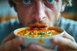 © pisan - Young Man Humorously Devouring Messy Spaghetti Dish with Tomato Sauce and Herbs