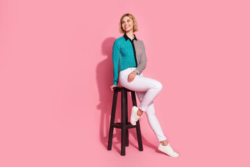 Poster - Full size photo of pretty young girl model sit chair look empty space wear trendy striped cyan outfit isolated on pink color background