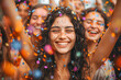 A delighted young woman with confetti on her face experiences pure joy among a crowd