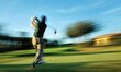 A golfer swinging his club at a golf club in motion