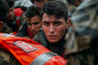 Intense young man in rescue gear, soaked, focused gaze amidst a crowd.