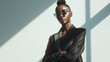 Stylish Woman with Sunglasses in Sunlight, Confident African woman posing in elegant black attire, accentuated by striking geometric shadows