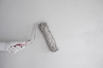 Poster - Painting the wall with a roller with white paint. Painting a bare wall with a roller with white paint. Apartment painting, renovation using white paint
